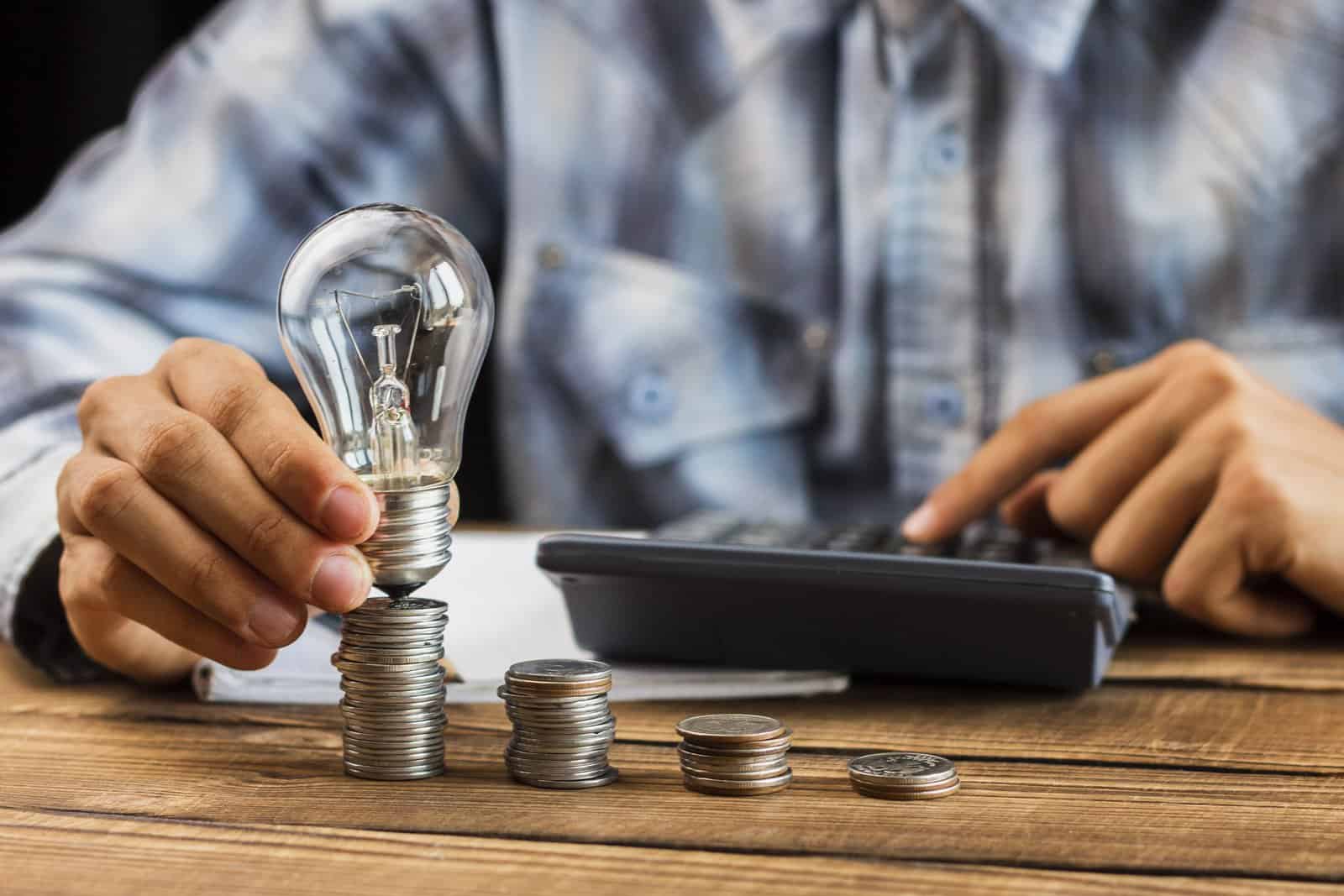 Imagen de una bombilla con monedas debajo